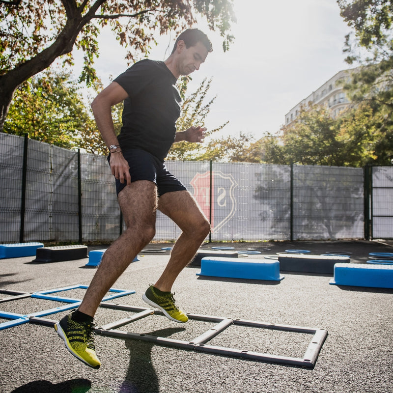 Person performing a jump exercise on a training grid outdoors