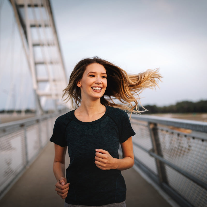 Woman running on a bridge with hair flowing